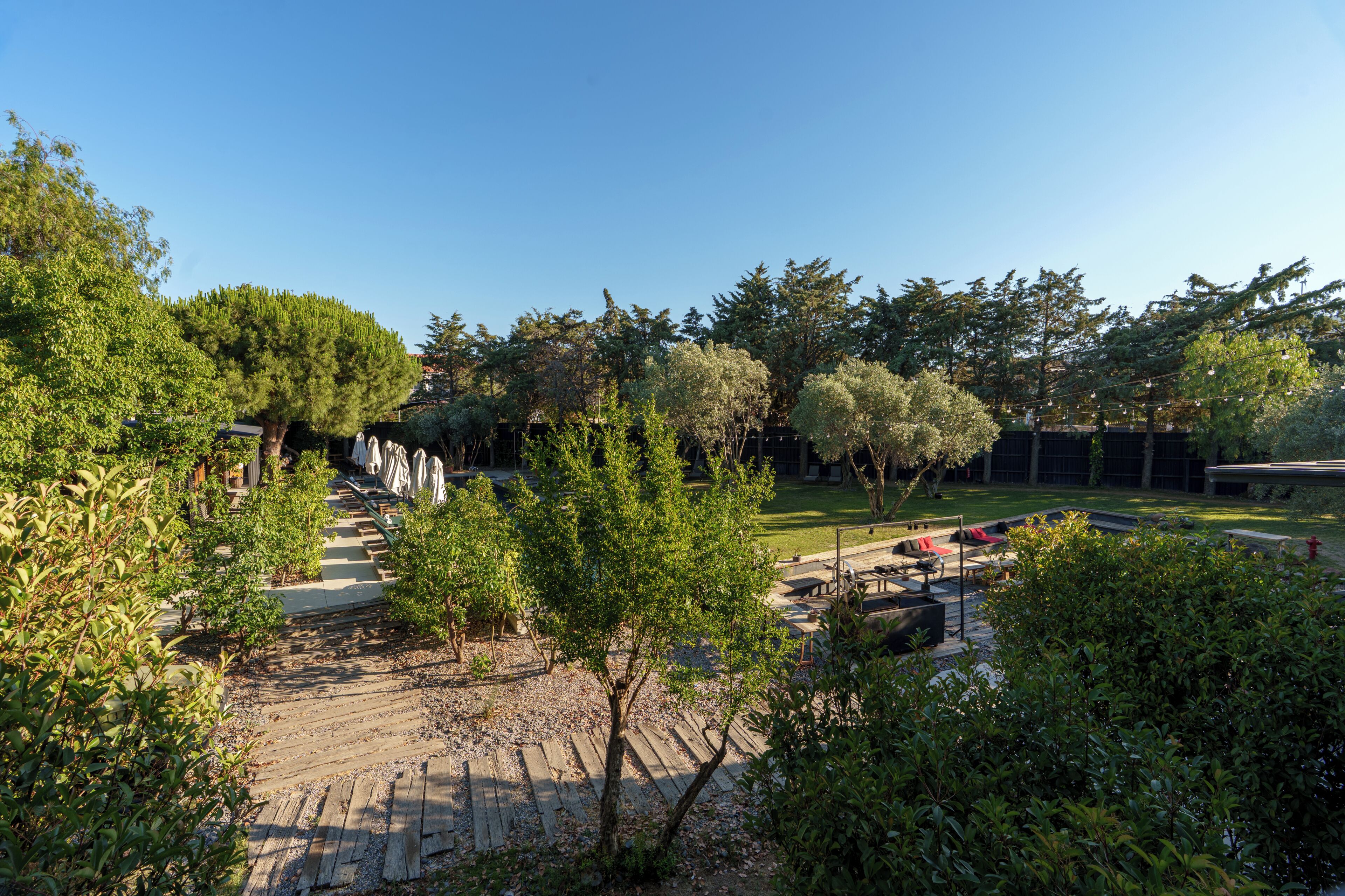 A courtyard with a wooden deck, seating area, and trees.