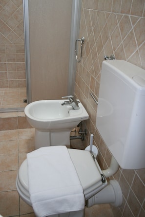 A bathroom with a toilet, bidet, and sink.