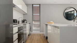 A modern kitchen with stainless steel appliances, a built-in oven, and a central island.