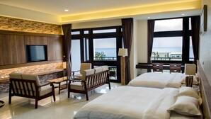 A hotel room with a large bed, a sofa, a TV, and a balcony with a view of the sea. - Hola sea view B&B (Shoufeng)