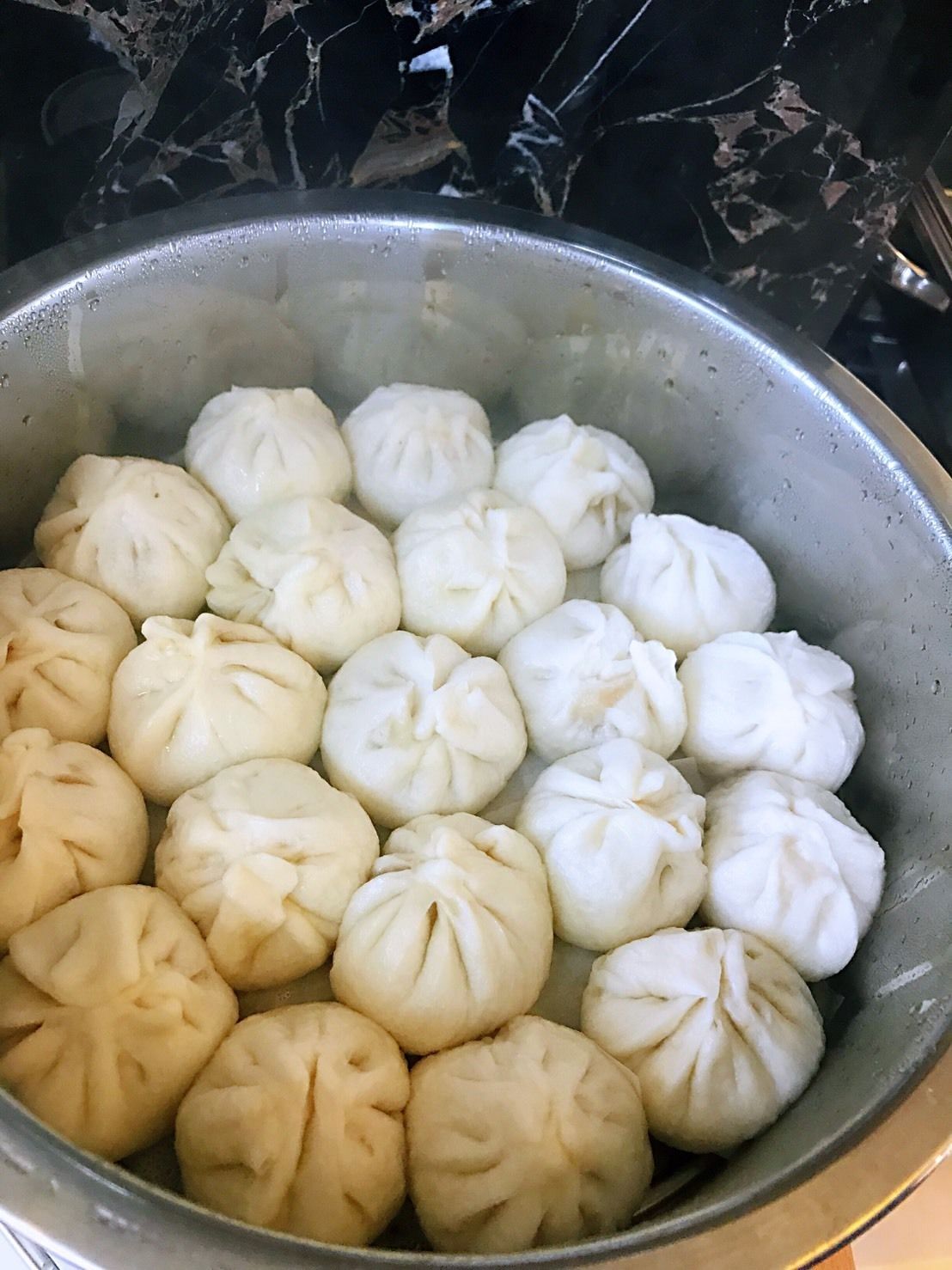 Una olla llena de bollos al vapor.