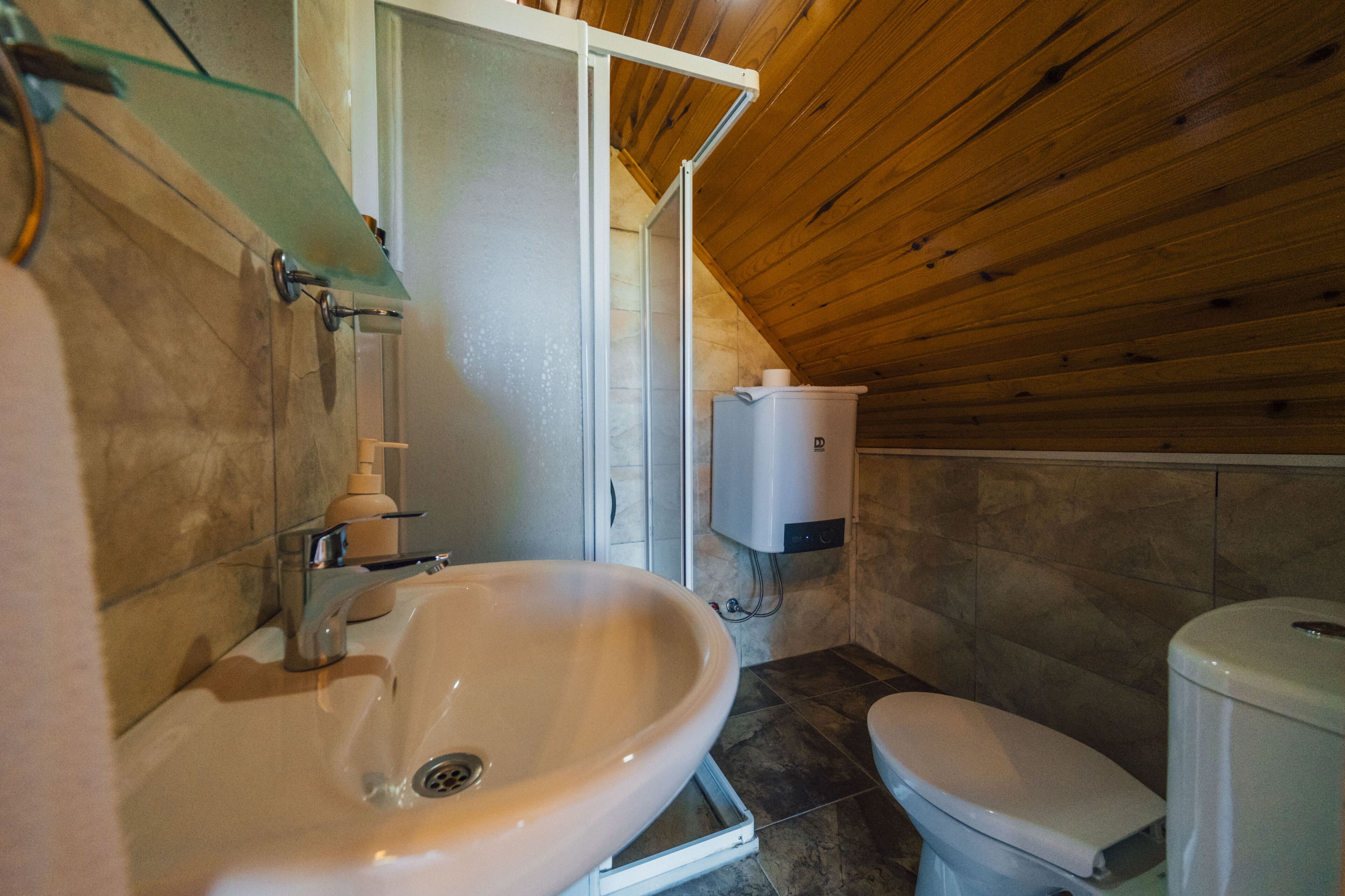 A bathroom with a sink, toilet, and shower area.