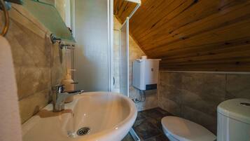 A bathroom with a sink, toilet, and shower area.