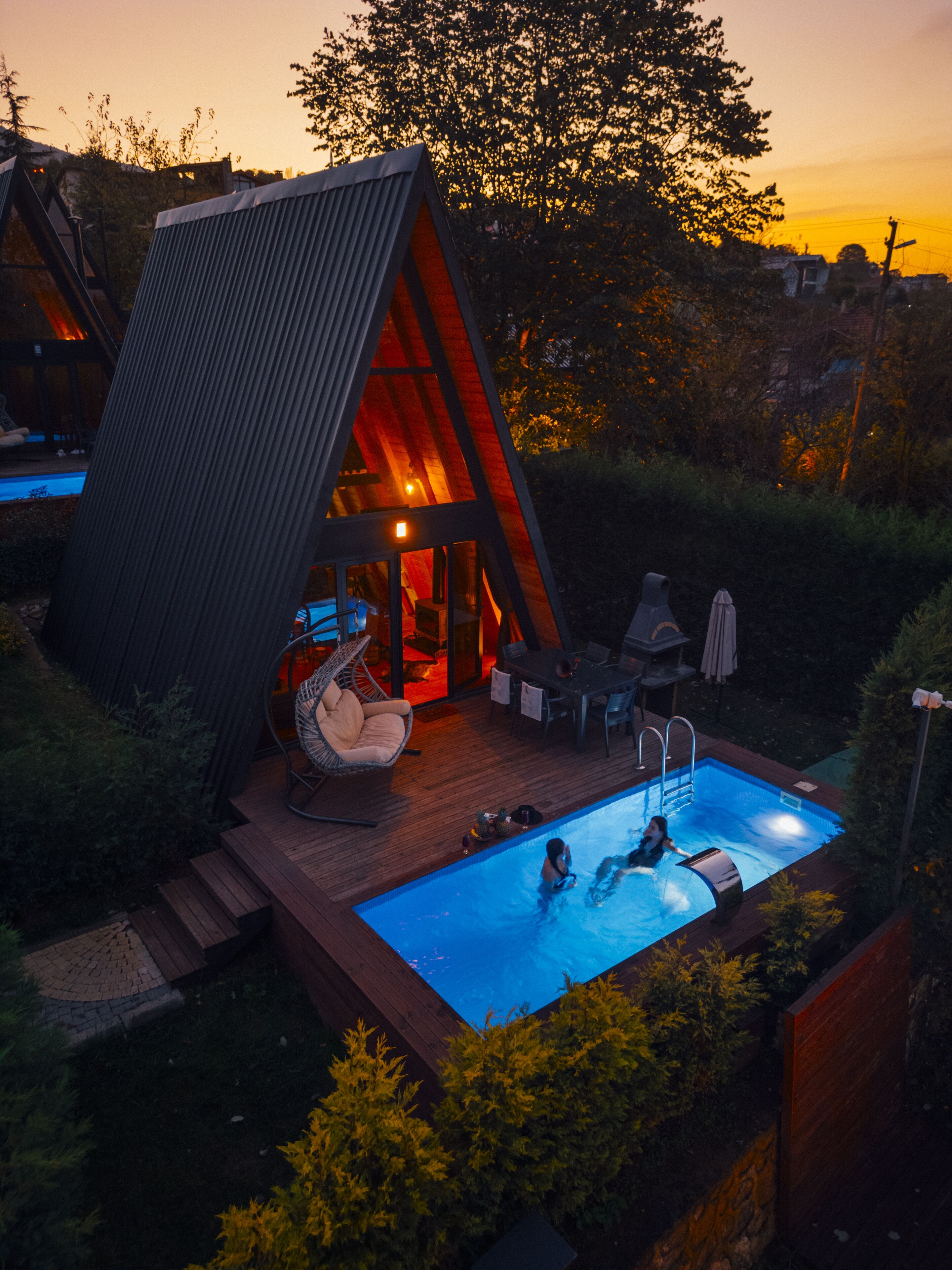 Une maison moderne dotée d’une piscine, d’une terrasse et d’un coin salon confortable.