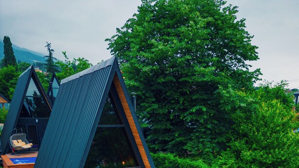 Una villa moderna con piscina, mobiliario de exterior y zona de comedor.