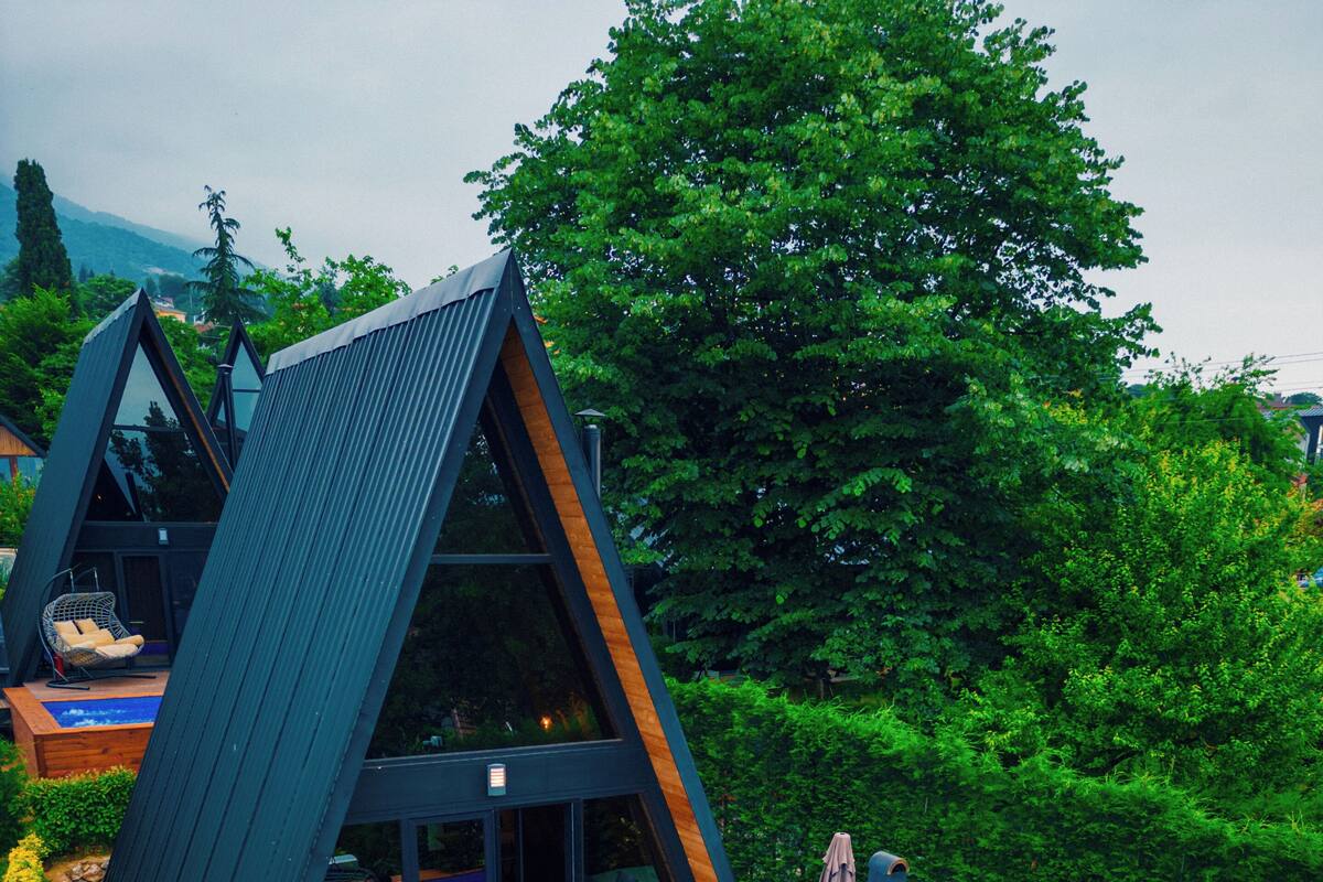Une villa moderne dotée d’une piscine, d’un espace salon extérieur et d’un coin repas.