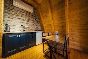 Un intérieur en bois avec un mur en briques, un évier, des placards et une table à manger.