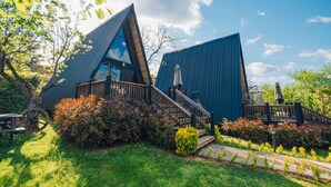 Un edificio moderno con techo triangular, terraza de madera y mesa de picnic.