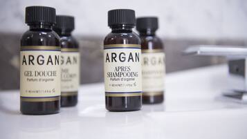 Four bottles of Argane gel douche and shampoo on a white surface.