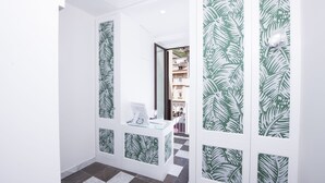 A hallway with a checkered floor, a reception desk with a computer, and walls with a green leaf pattern. - La Bambagina (Amalfi)
