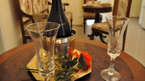 A bottle of champagne, two glasses, and a rose on a table. - Casa Ardizzoni (Bologna)