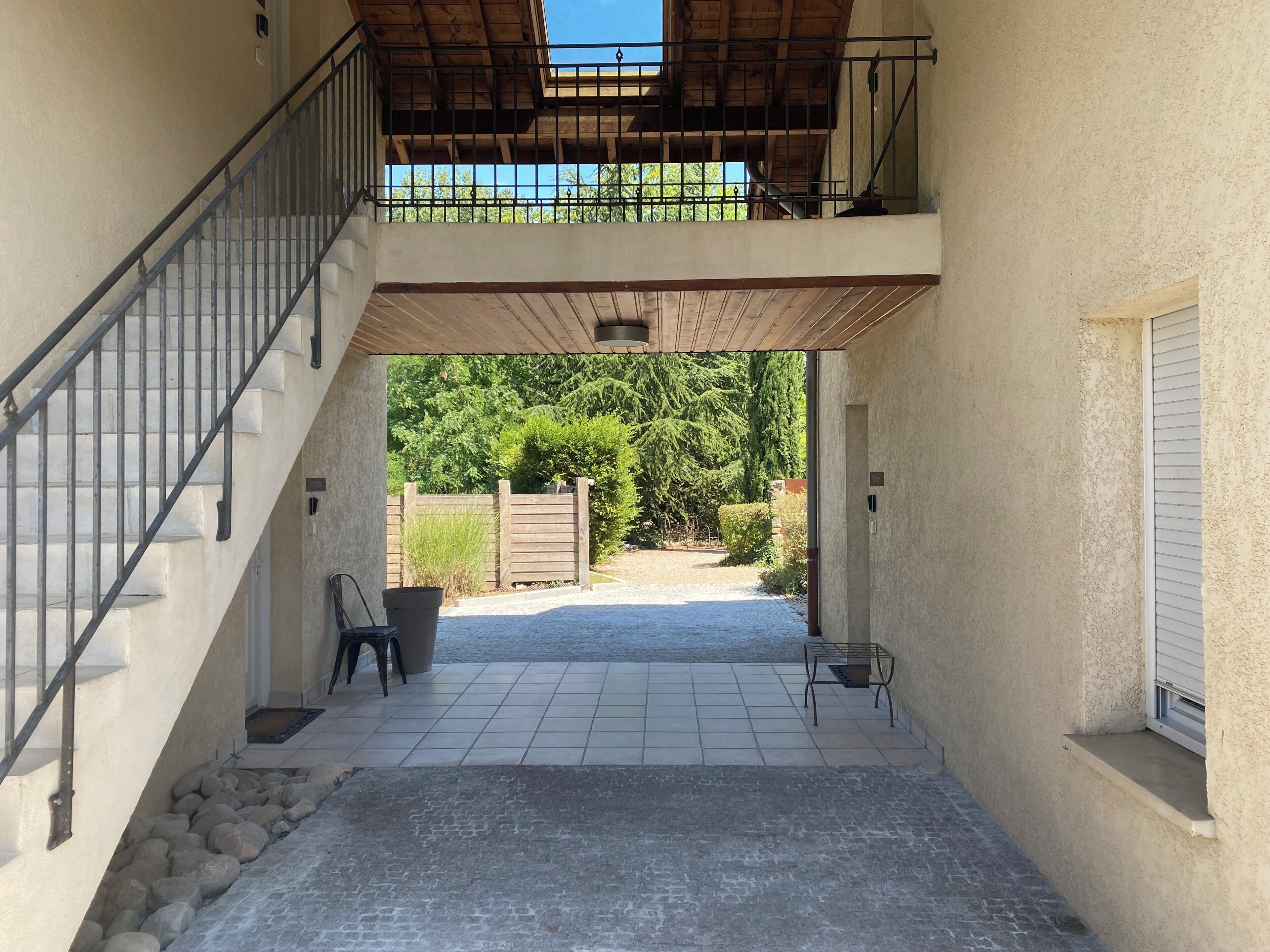 Un espacio al aire libre cubierto con una escalera, una zona de estar y vistas al jardín.
