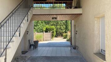 Un espacio al aire libre cubierto con una escalera, una zona de estar y vistas al jardín.