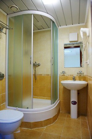 Ein Badezimmer mit Duschkabine, Waschbecken und Toilette.