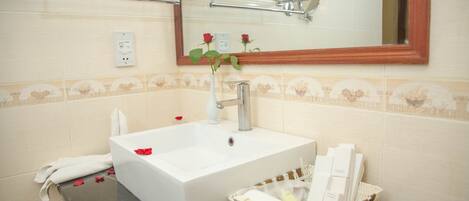 A bathroom with a white sink, a mirror, and a towel rack.