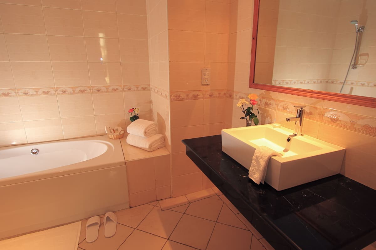 deluxe suite, 1 queen bed, non smoking | bathroom | deep-soaking bathtub, rainfall showerhead, free toiletries, hair dryer