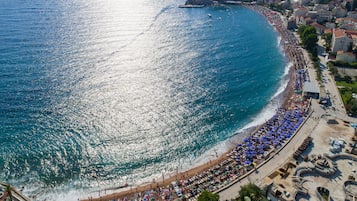 Una spiaggia nelle vicinanze, sabbia bianca, lettini da mare, ombrelloni