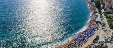 Una playa cerca, arena blanca, sillas reclinables de playa, sombrillas