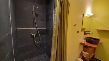 Un baño con ducha, lavamanos e inodoro.