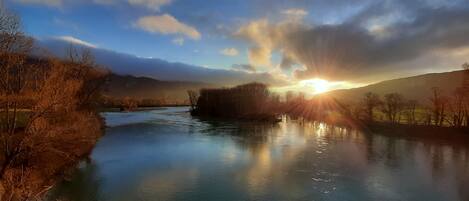 A river with trees on the banks and a clear sky.