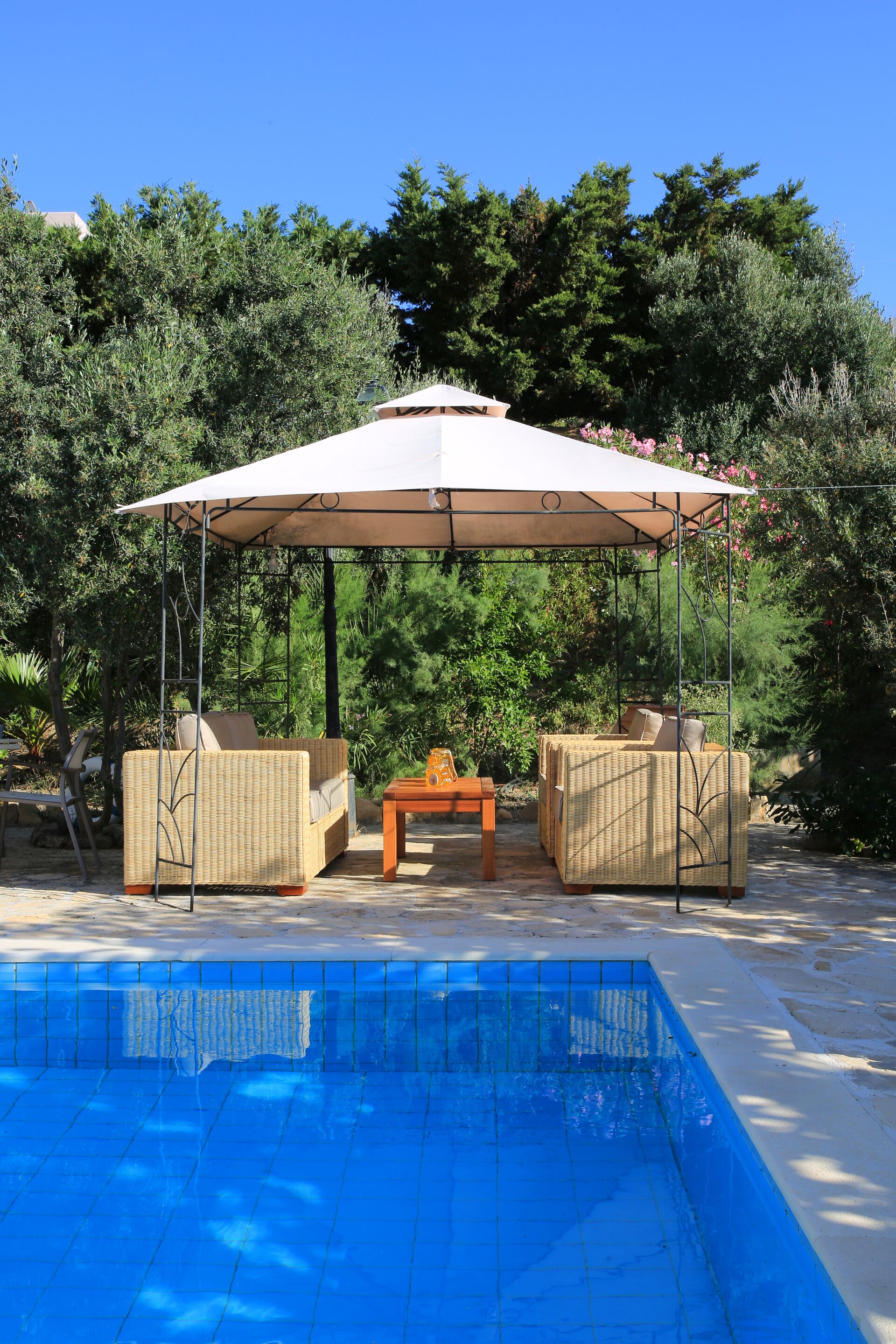 A poolside area with a covered seating area and a pool.