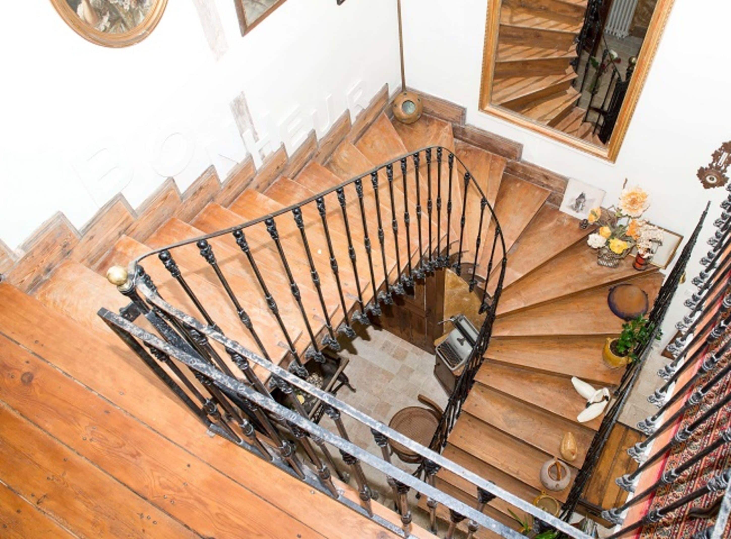 A spiral staircase with wooden steps and a metal railing.