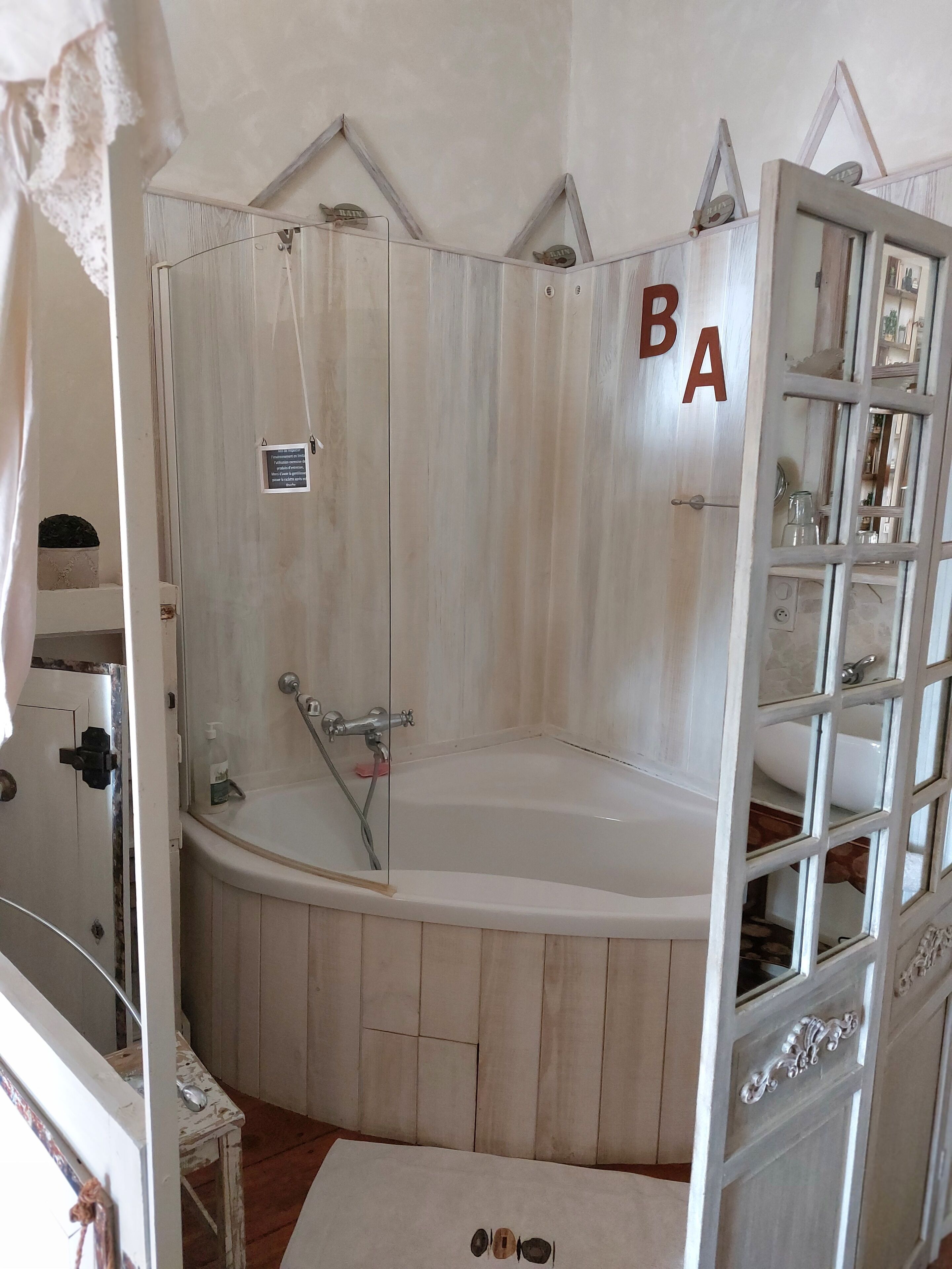 Un baño con tocador de madera, bañera y zona de ducha.