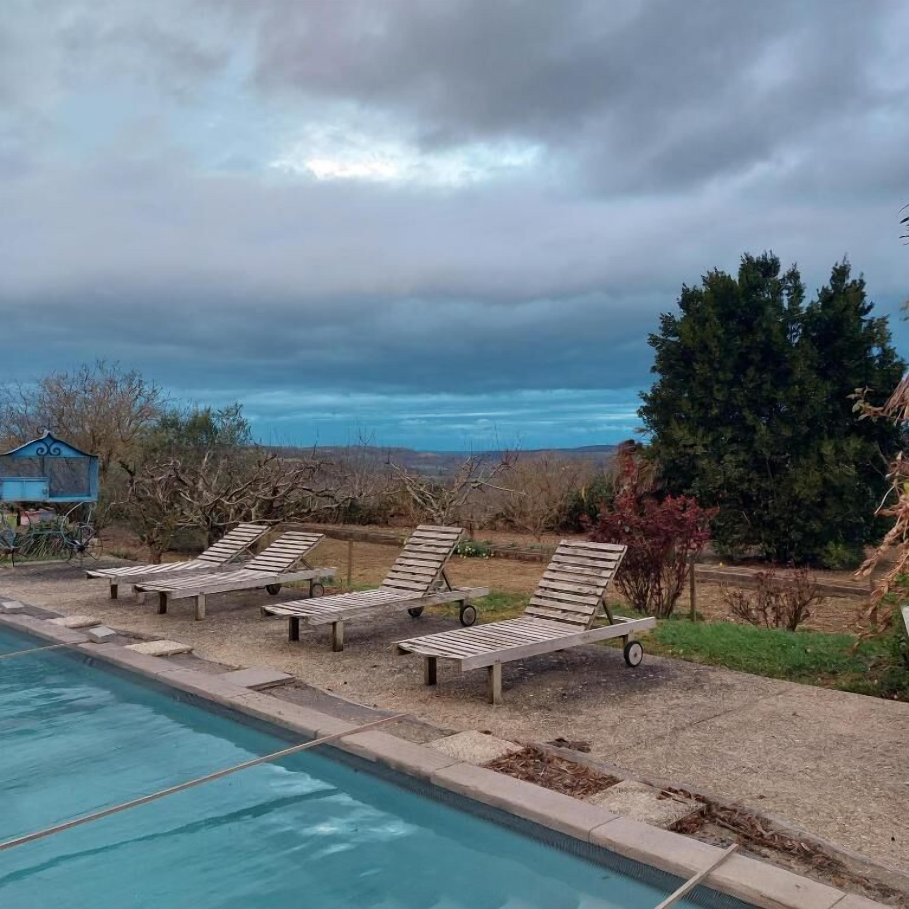 Une piscine dotée de chaises longues et offrant une vue sur le paysage.