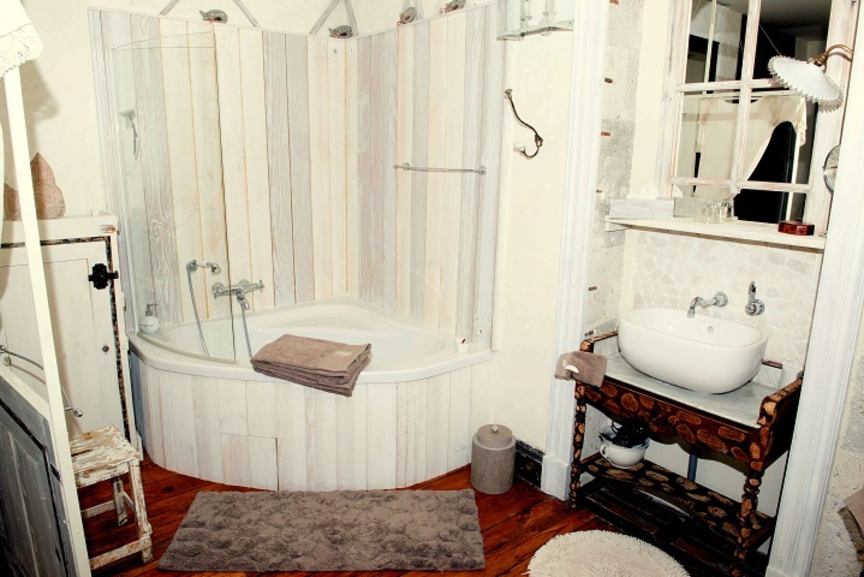 Un baño con bañera, lavabo y espejo.