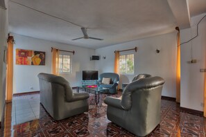Un salon équipé d’un ventilateur de plafond, d’un téléviseur à écran plat et d’une table basse.