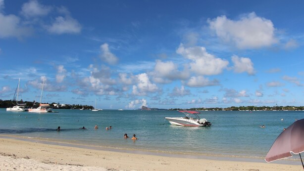 A beach with boats, people swimming, and a clear sky. - Hibiscus Villa (Grand-Baie)