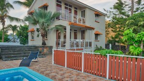 A two-story house with a swimming pool, a balcony, and a wooden fence. - Hibiscus Villa (Grand-Baie)
