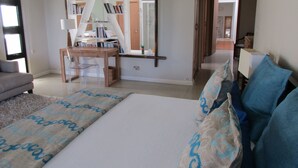 Een slaapkamer met een bed, een bureau, een stoel en een kledingkast.