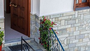 Una escalera de piedra con barandillas de metal que conduce a una puerta de madera.