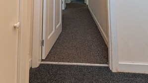 A narrow hallway with carpeted floors and white walls. - Perfect Flat in Central Edinburgh (Edinburgh)