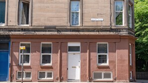 A two-story building with a sign reading "DALRY ROAD" above the entrance. There is a small window with a sign indicating "GREENWAY" and "NO PARKING." - Perfect Flat in Central Edinburgh (Edinburgh)