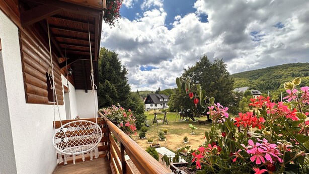 A wooden balcony with a white chair and a flower box. - Plitvice Green Valley (Plitvicka Jezera)