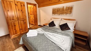 A bedroom with a bed, wooden wardrobe, and a painting on the wall. - Plitvice Green Valley (Plitvicka Jezera)
