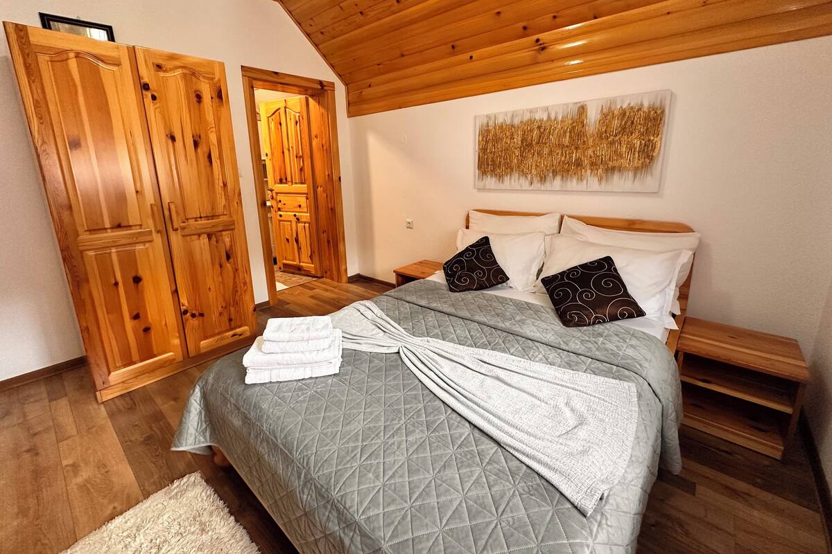 Un dormitorio con cama, armario de madera y un cuadro en la pared.