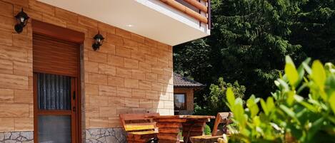 A log cabin with a stone foundation, a wooden door, and a stone wall.