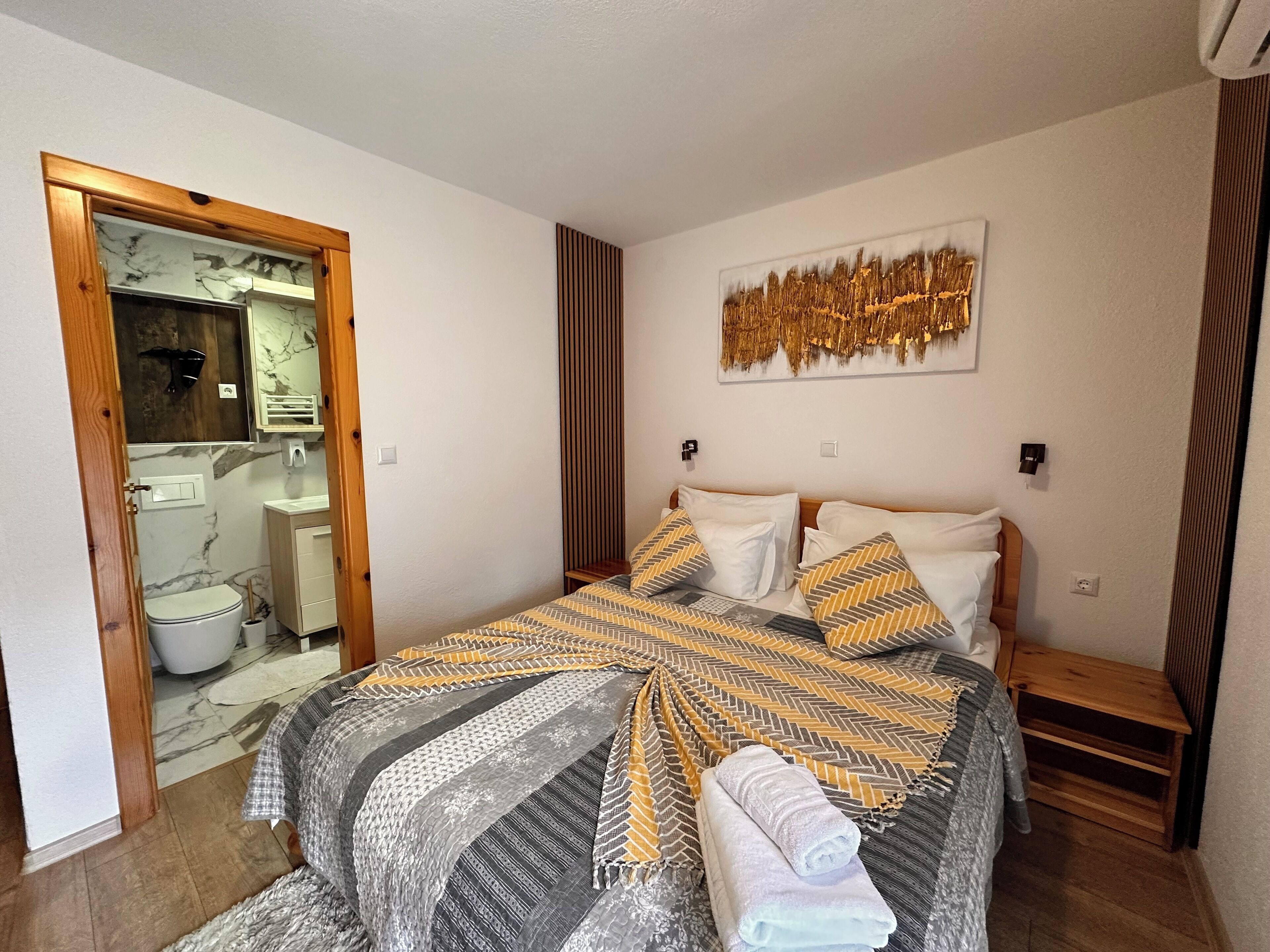 A bedroom with a bed, a bathroom, and a hallway.
