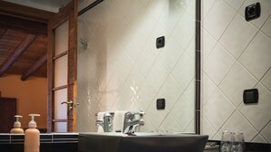 A bathroom with a large mirror, a black sink, and a shower area. - A Corona del Reino (Ejea De Los Caballeros)