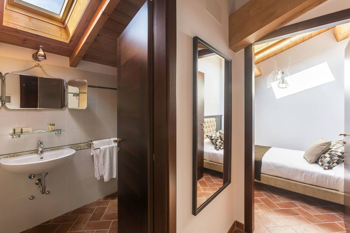 A modern bathroom with a sink, mirror, and towel rack.