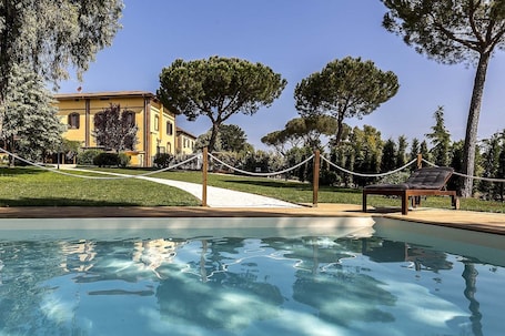 Una piscina al aire libre de temporada, sillones reclinables de piscina
