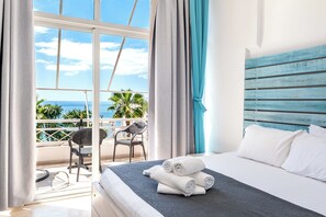 A hotel room with a bed, a balcony with a chair, and a view of the ocean. - Saranda Hotel (Sarandë)