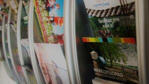 A wall with various posters and flyers, including one with a rope and trees and another with a group of people. - Stadshotel Rijssen (Rijssen)