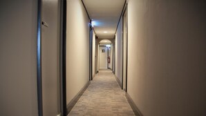 A long, narrow hallway with carpeted floors and doors on both sides. - Stadshotel Rijssen (Rijssen)