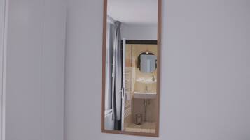 A bathroom with a mirror, sink, and towel rack.