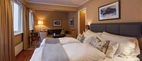 Una camera d'albergo con un letto grande, una scrivania, una sedia e una lampada.