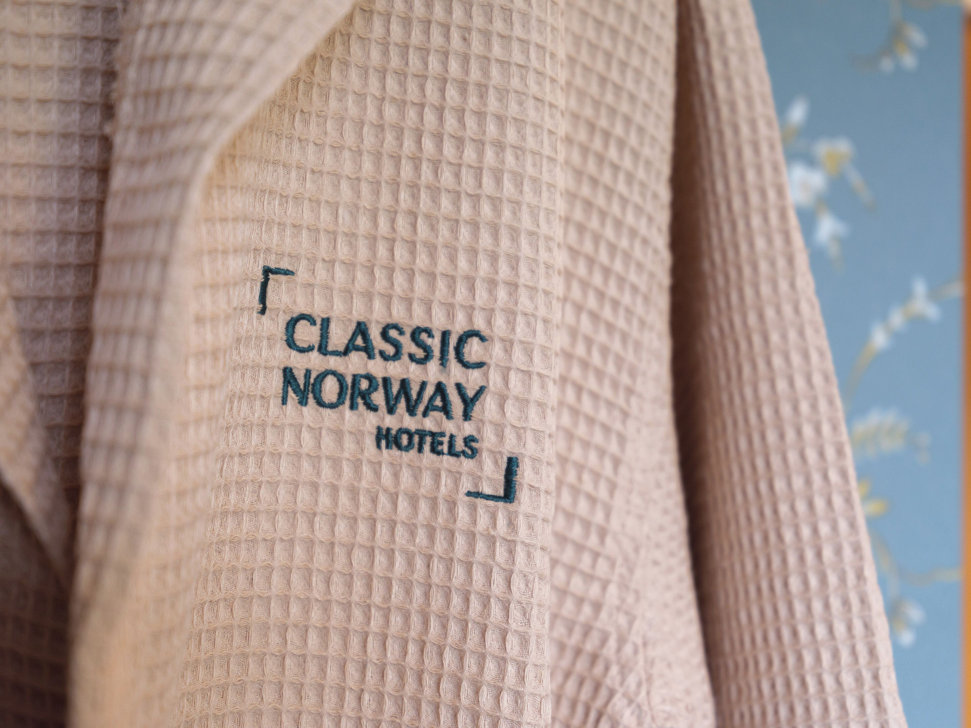 A textured fabric with embroidered text reading "CLASSIC NORWAY HOTELS".